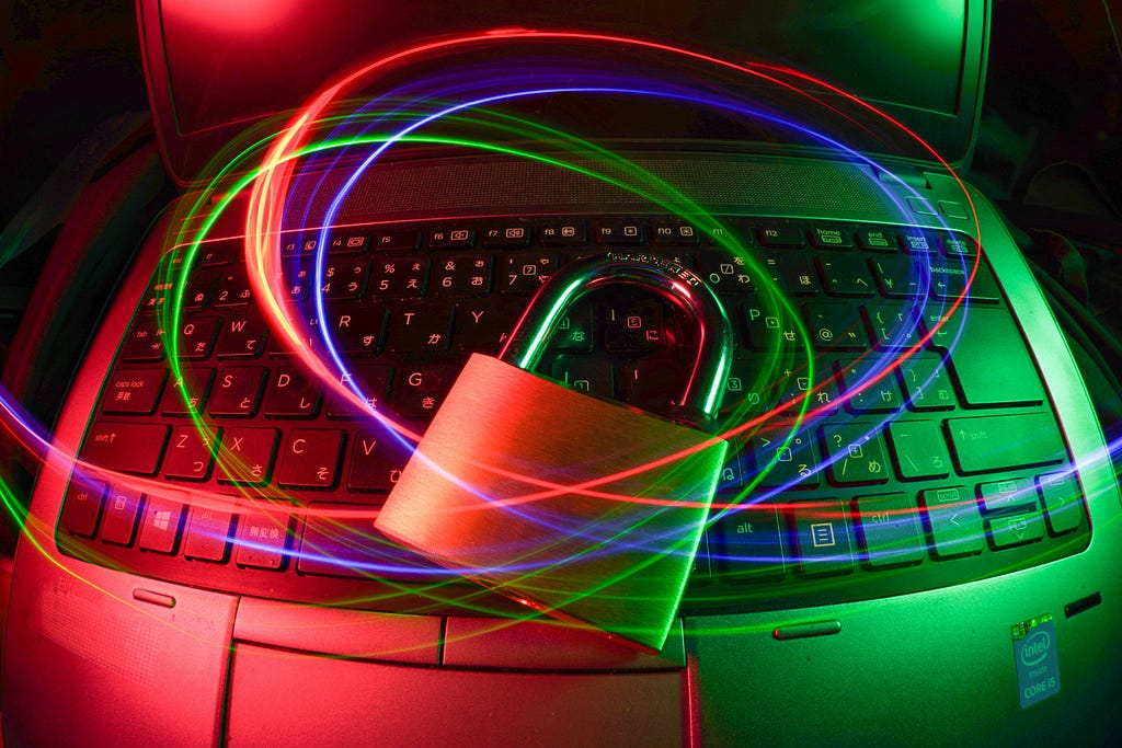 A padlock on a laptop keyboard, surrounded by colored light trails.